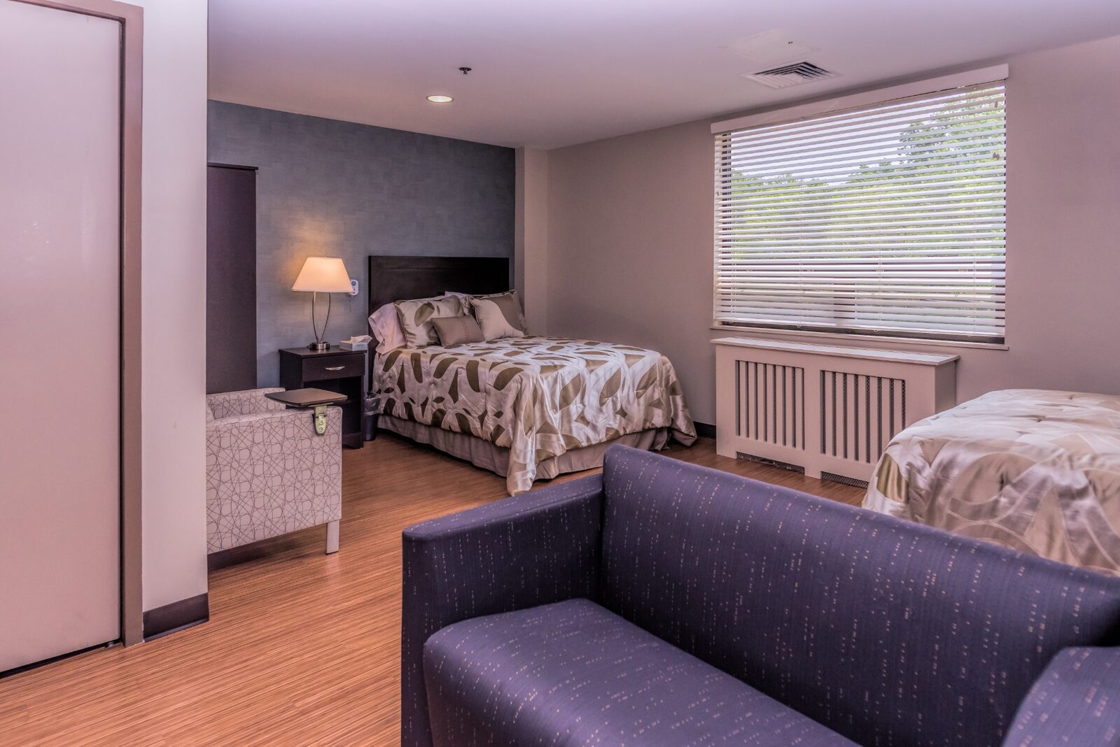 Room with two beds, an armchair and a sofa
