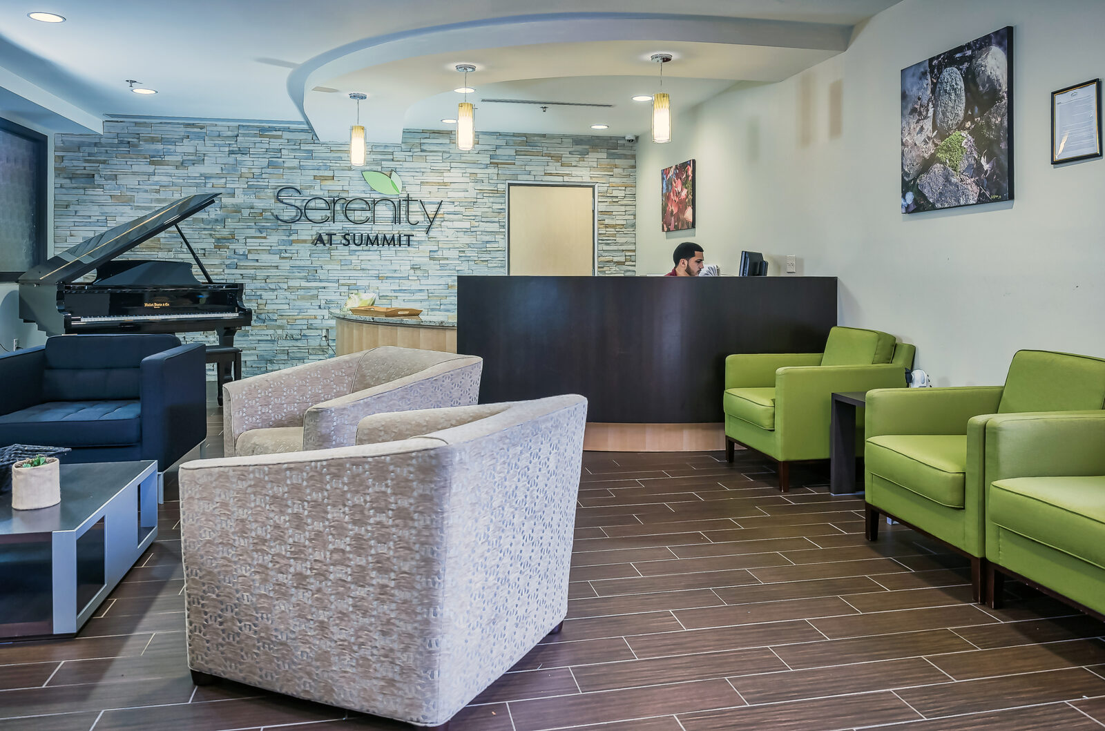Lobby with a piano, stone wall and reception desk